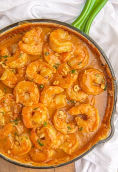 a skillet filled with cooked shrimp and garnished with parsley