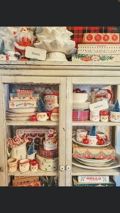 an old china cabinet is decorated with christmas dishes and other holiday decorating items, including santa's sleigh