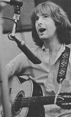 an old black and white photo of a woman singing into a microphone while holding a guitar