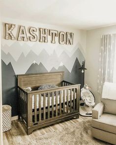 a baby's room with mountains painted on the wall and a crib in the corner