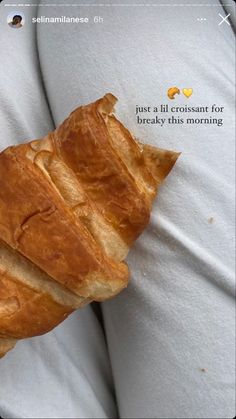 a close up of a person holding a large piece of bread in their hands with the caption just a lil croissant for breakfast this morning