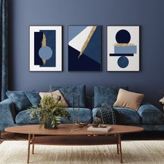 a living room with blue couches and paintings on the wall above them, along with a coffee table