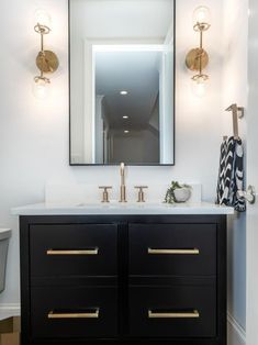 a bathroom vanity with two sinks and a large mirror above it in a white walled room