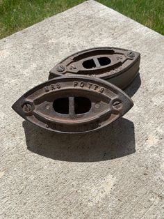 two metal objects sitting on top of a cement slab