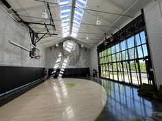 an indoor basketball court with lots of windows