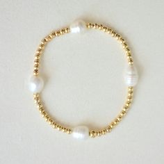 Our gold-filled beaded bracelet and pearls is the epitome of versatile elegance. Perfect for any occasion, these classic and timeless pieces are designed for everyday wear. Adorn yourself with effortless sophistication. The beads are strung on a premium stretch cord.SOLD BY ONE BRACELETDETAILS:- 14K Gold-filled beads, Natural Freshwater Pearls ( due they are natural pearls may vary the size and shape) What is 14k Gold-Fiiled ? Gold-filled jewelry is a type of jewelry that consists of a layer of Gold Bond, Pure Gold, Base Metal, Gold Filled Jewelry, Shape Design, Natural Pearls, Gold Plated Jewelry, How To Make Beads, Pearl Beads