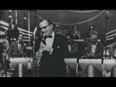 an old black and white photo of a man in a tuxedo playing the trumpet