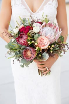 a woman holding a bouquet of flowers in her hands