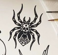 a drawing of a spider on paper with pencils next to it and an ink pen