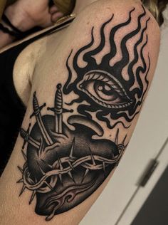 a woman's arm with an eye and dagger tattoo on the left side of her body