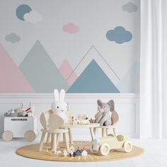 a child's room with mountains painted on the wall and wooden toys in chairs