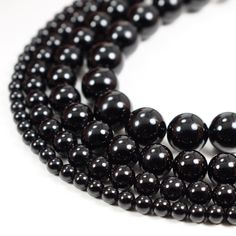 three strands of black beads on a white background