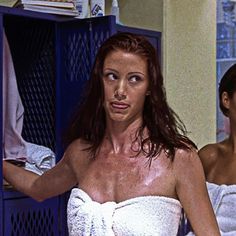 two women in towels standing next to each other and one is holding a towel over her shoulder