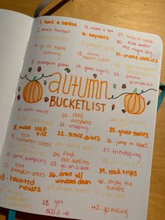 an open notebook with the words autumn bucket list written in orange and green on it