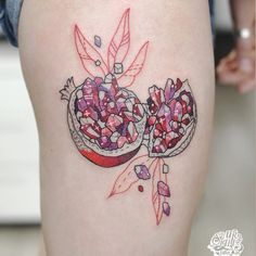 a woman's thigh with some candy in the shape of two pomegranates