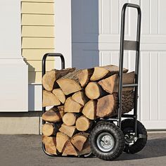 a hand truck loaded with logs in front of a garage