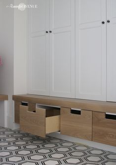 an empty room with white cabinets and drawers