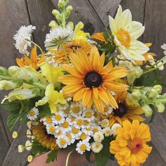 a person holding a bouquet of yellow and white flowers