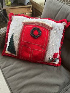 a red door pillow sitting on top of a couch