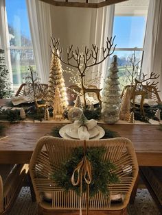 a dining room table decorated for christmas with trees and other holiday decorations on the table