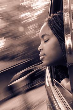 a woman with her eyes closed sitting in a car