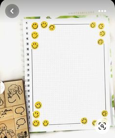 a notebook with smiley faces on it next to a rubber stamp and some other items