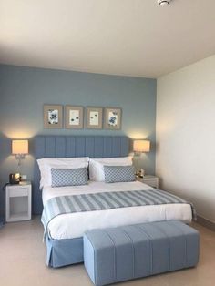 a bedroom with blue walls and white bedding, two lamps on either side of the bed