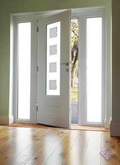 an empty room with three doors and hard wood flooring on either side of the door