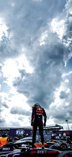 a man standing on top of a race car