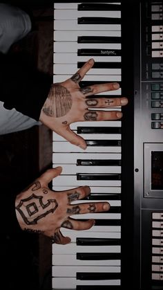 two hands that are on top of a piano keyboard with numbers painted on the keys