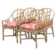 three bamboo chairs with pink cushions on them