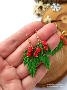 a pair of red berries and green leaves earrings