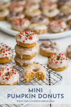 mini pumpkin donuts with frosting and sprinkles on a cooling rack