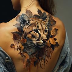 a woman with a tattoo on her back that has leaves and a tiger's face