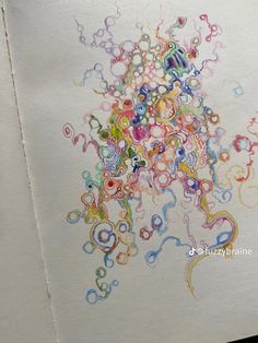 an art project with colored circles and bubbles on paper, in the process of being drawn