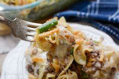 a fork full of pasta with meat and vegetables