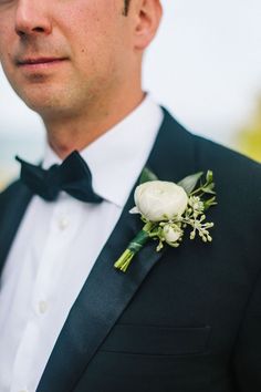 a man in a tuxedo with a boutonniere on his lapel