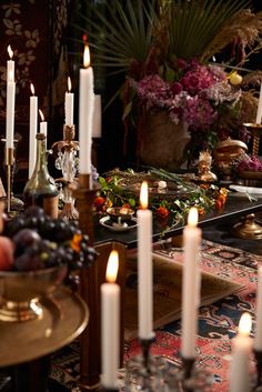 a table topped with lots of candles and fruit