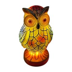 an orange and yellow owl lamp sitting on top of a table