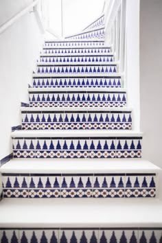 a set of stairs with blue and white designs on the riser, along with an instagram page