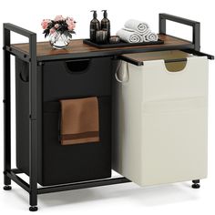 a black and white cabinet with two bins on it's sides next to a trash can