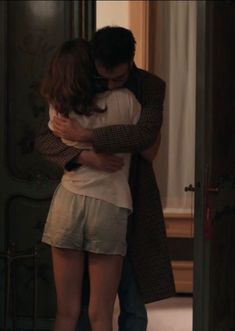 a man and woman embracing each other in front of a mirror