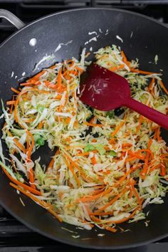 shredded carrots and cabbage cooking in a skillet