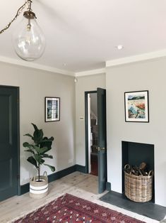 a living room filled with furniture and a fire place next to a plant in a basket