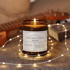 a candle sitting on top of a table next to a string of lights and a guitar