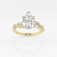 a yellow gold engagement ring with a pear shaped diamond in the center and side stones