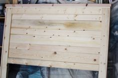 a large wooden sign sitting on top of a pile of wood planks in a room