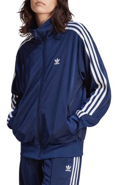 The brand's iconic 3-Stripes make an appearance tracing the shoulders and sleeves of a sporty track jacket crafted with a loose fit for more room to move. Front zip closure Stand collar Front zip pockets 100% recycled polyester Machine wash, tumble dry Imported Quoi Porter, Adidas Tracksuit, Shiny Fabric, Women Lifestyle, Firebird, Blue Adidas, Look Casual, Adidas Online, How To Look Classy