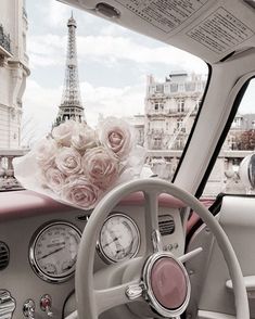 the interior of an old car with roses in front of the eiffel tower