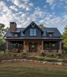 a large house with a metal roof and stone pillars